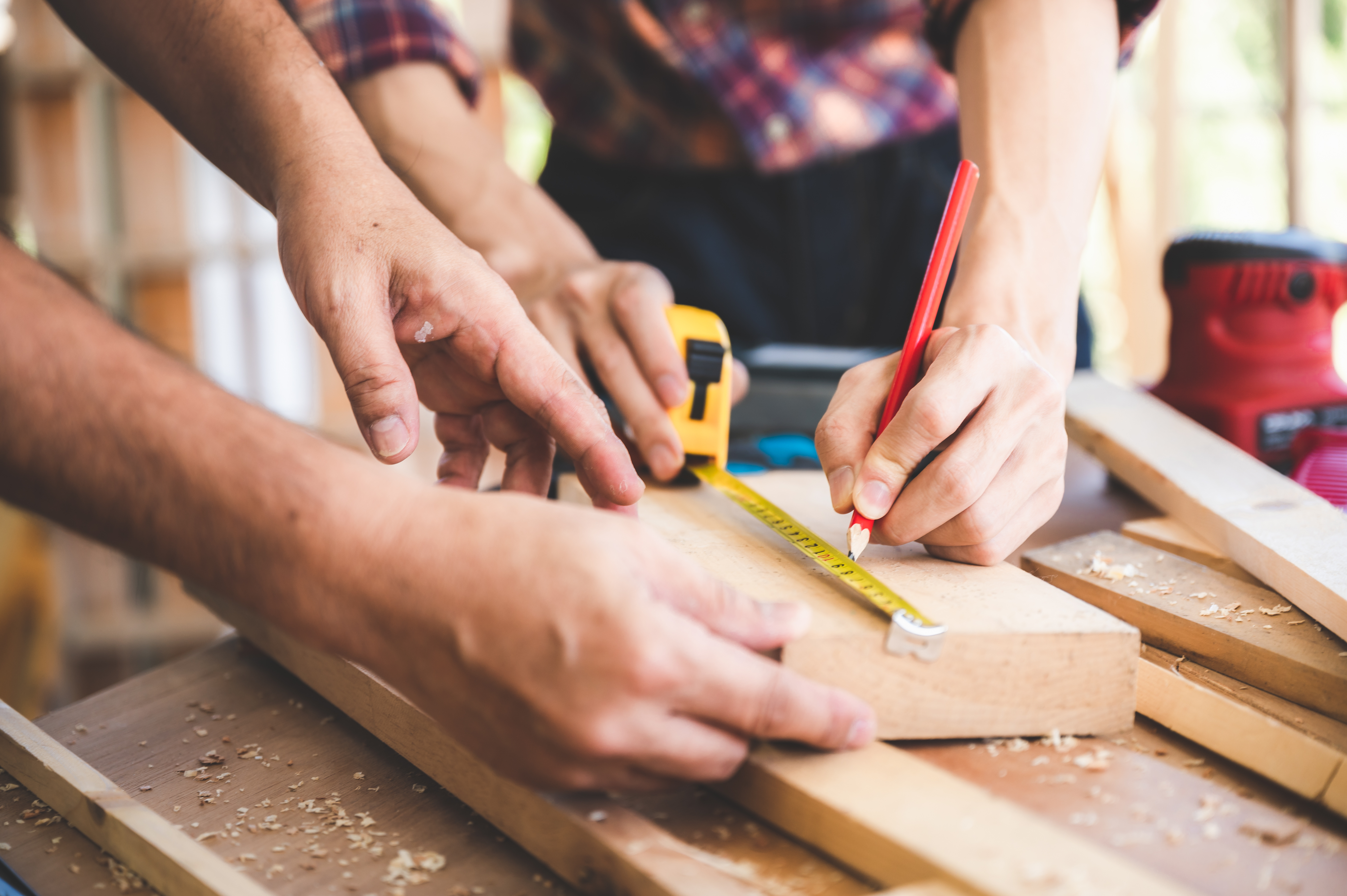 Two sets of hands working on a woodwork project