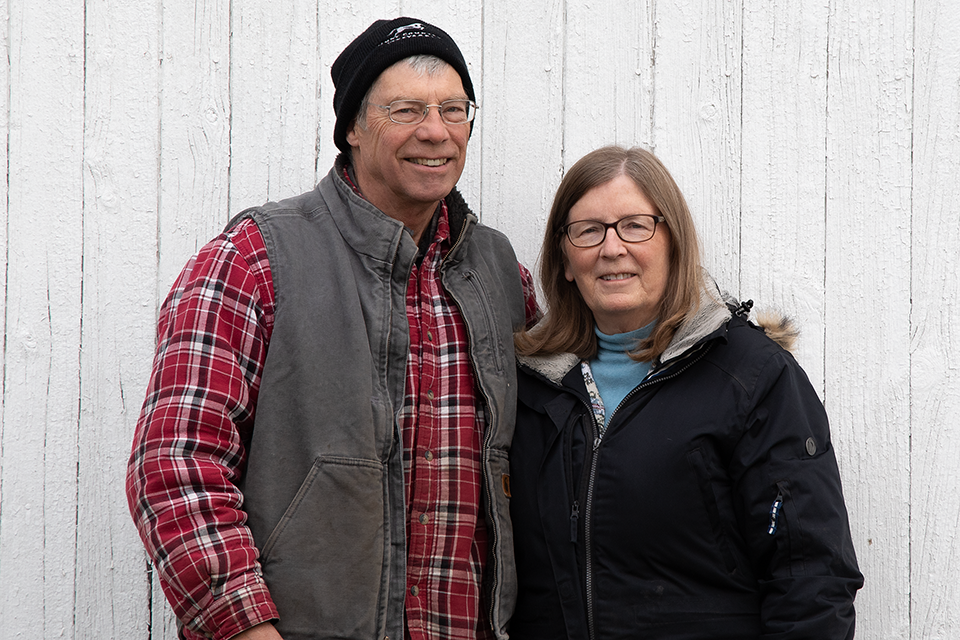 Image of Art and Joyce in front of barn door.
