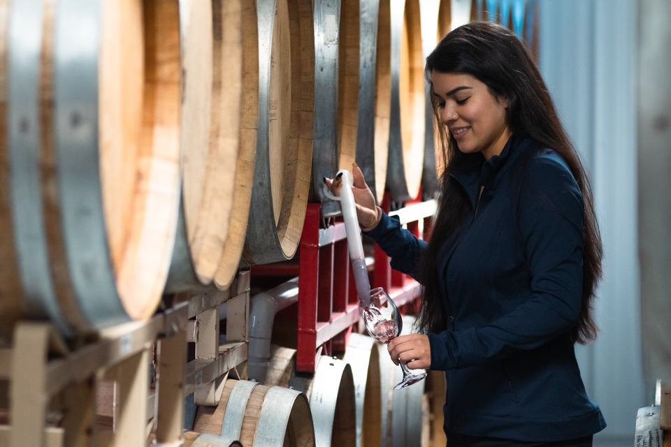 Image of Emily getting wine from a barrel.